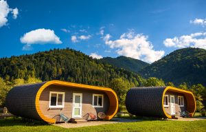Family enjoying a campsite with RV, picnic table, and campfire.